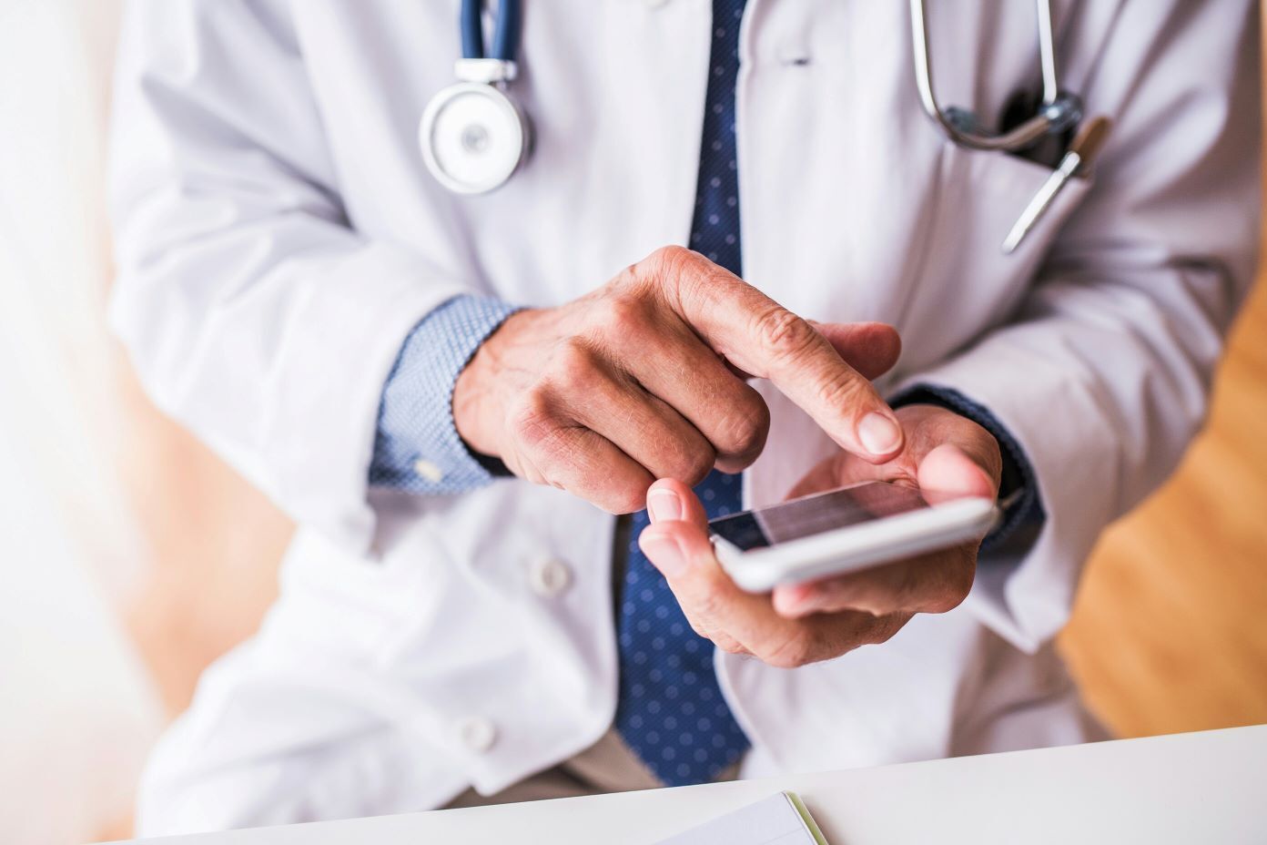 Le doigt d’un médecin touche l’écran d’un téléphone intelligent.