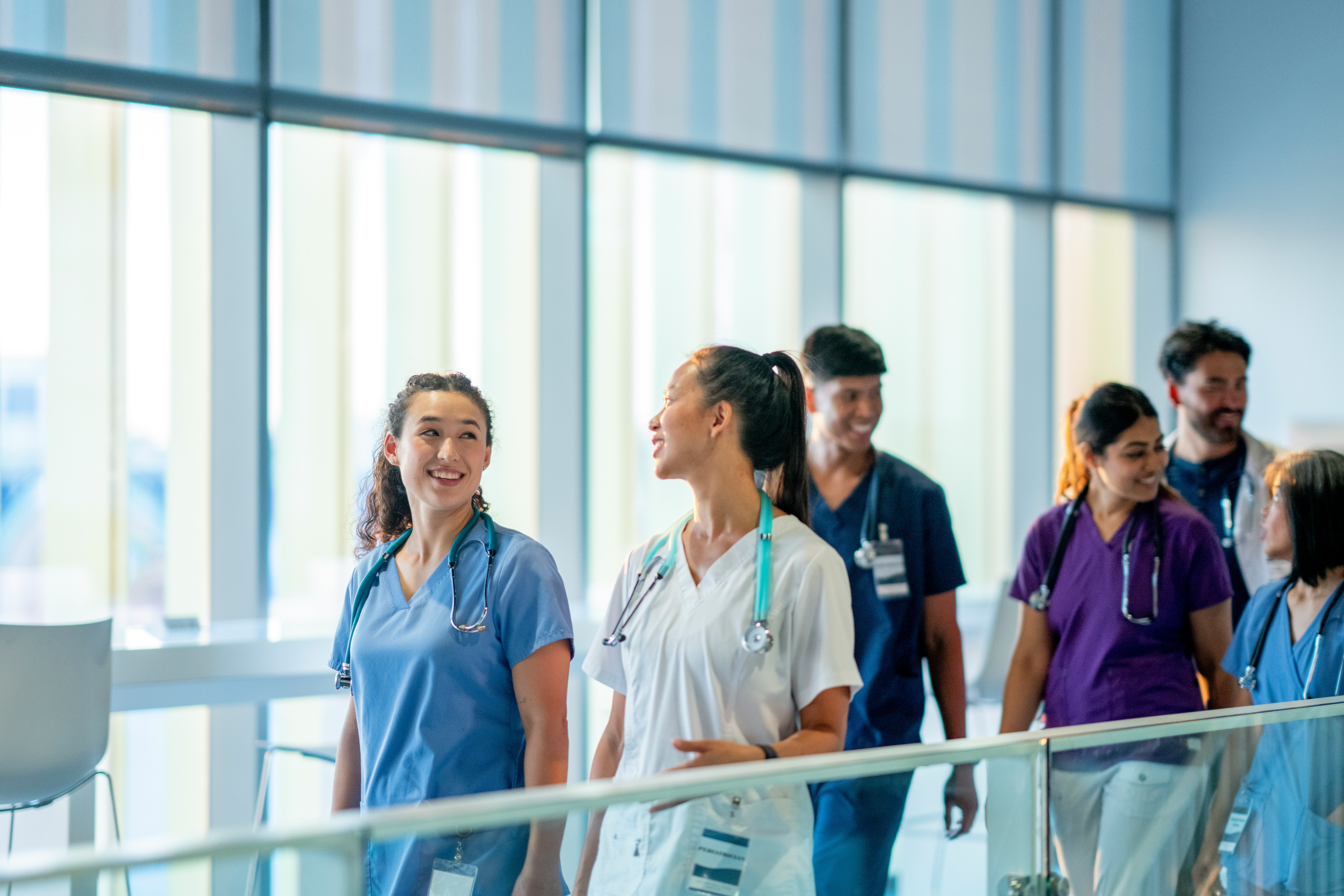 A group of care providers walks through a hospital.